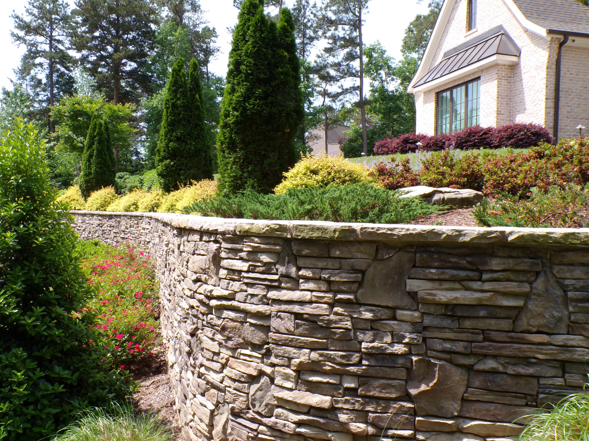 Layered landscape with evergreens, shrubs, and perennial color